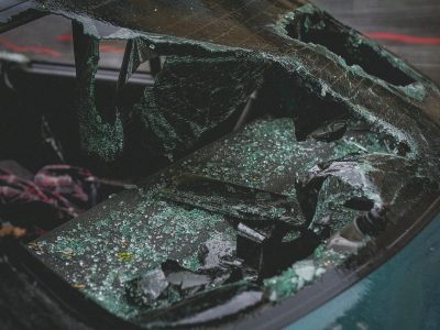 Detailed view of shattered car windshield after accident, emphasizing damage and broken glass.